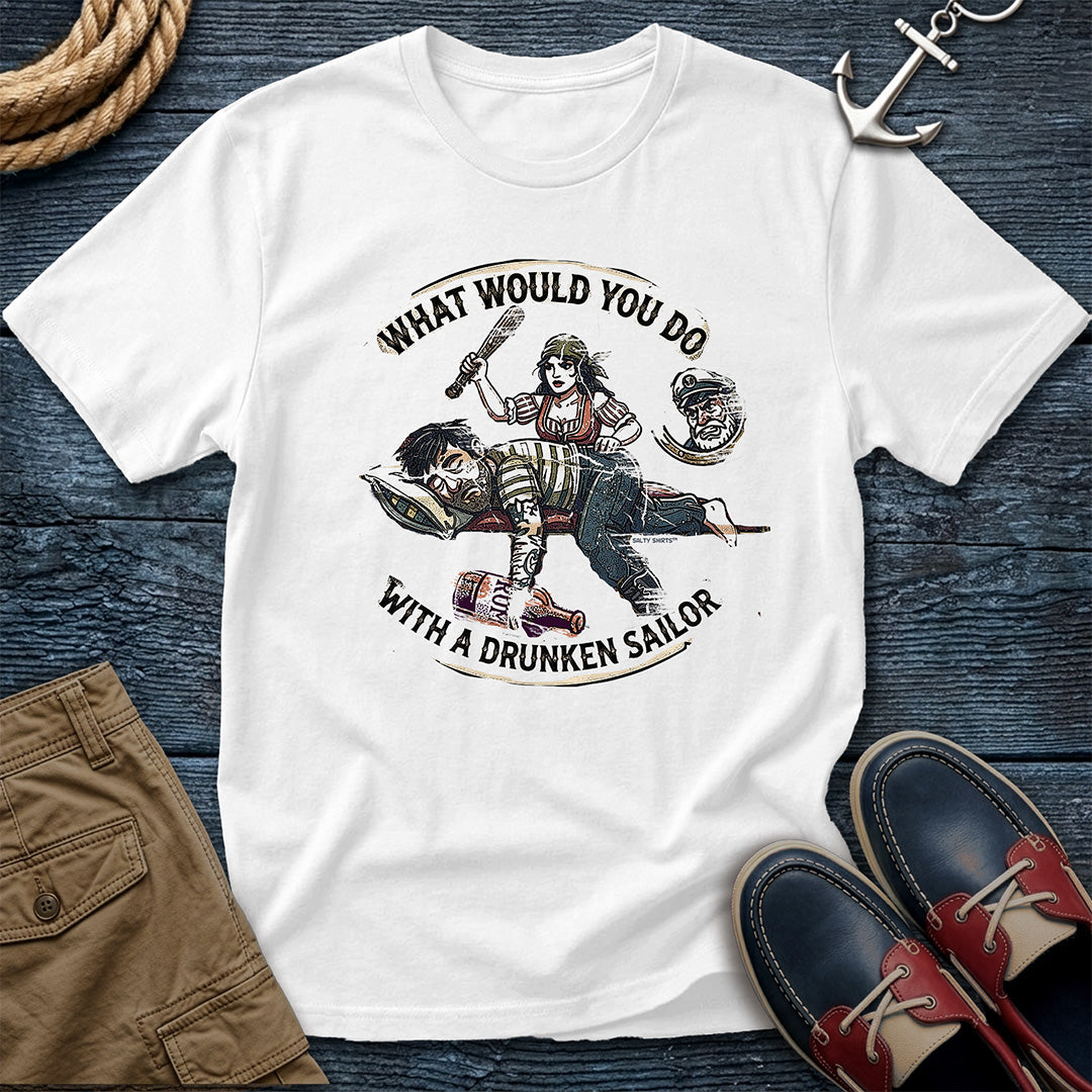 Drunken Sailor Shanty Tee in White: flat lay of a Comfort Colors 1717 tee on dark weathered wood with rope, an anchor keychain, khaki pants, and boat shoes. Distressed woodcut print shows a woman with a club swinging at a passed-out drunken sailor holding a rum bottle, framed by the text "What Would You Do With a Drunken Sailor."