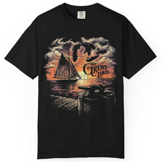 Black t-shirt with a graphic design of a sailboat and dock on a white background