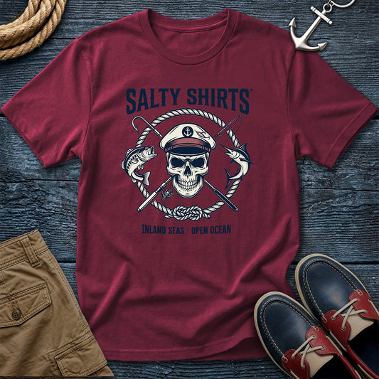 Brick t-shirt with skull and anchor design on a wooden surface with shorts and shoes.