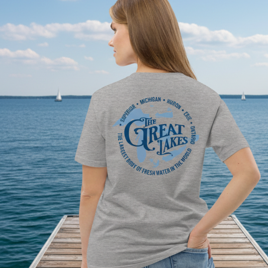 Person wearing a gray t-shirt with 'The Great Lakes' text on the back, standing on a dock by water.