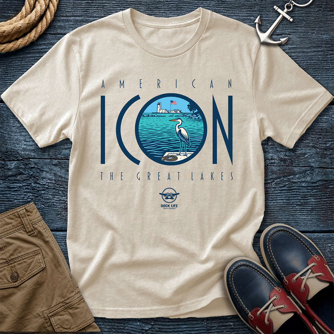 Beige t-shirt with 'American Icon The Great Lakes' design on a wooden surface with shorts and shoes.