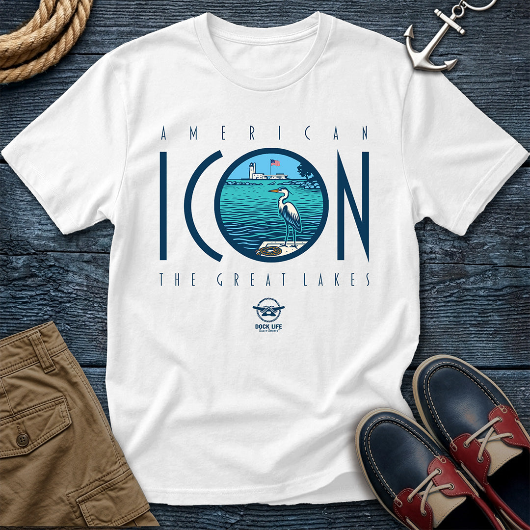 White t-shirt with 'American Icon The Great Lakes' design on a wooden surface with shorts and shoes.