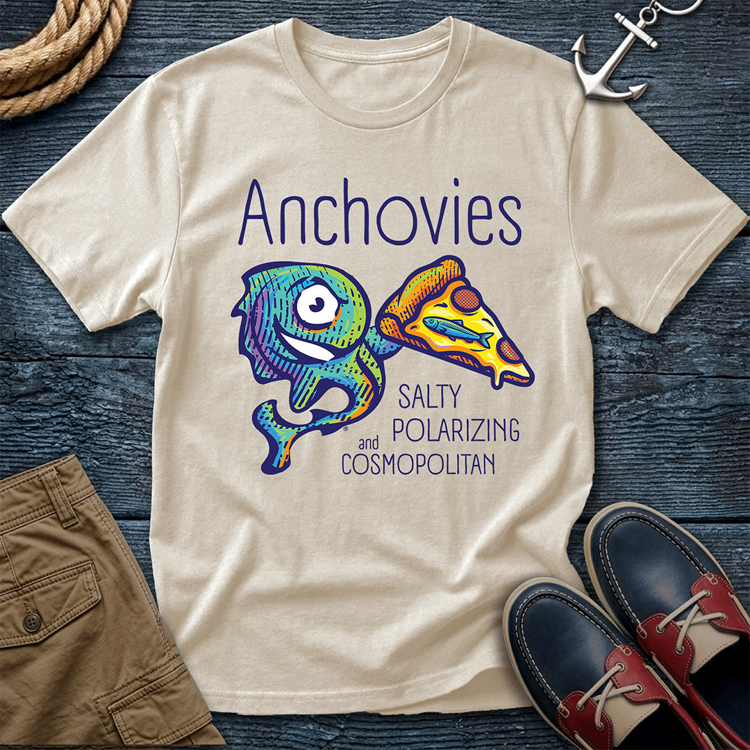 An Ivory short-sleeve crewneck t-shirt featuring a colorful graphic of Salty the anchovy mascot diving into a pizza slice, with the text 'Anchovies SALTY POLARIZING and COSMOPOLITAN' printed on the front.