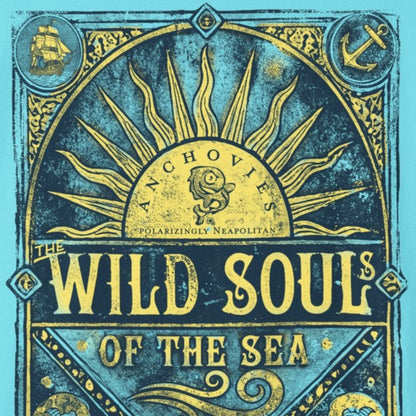 A light blue short-sleeve t-shirt with a large vintage-style graphic on the front featuring a sun, waves, and the text 'WILD SOUL OF THE SEA' in gold and dark blue.