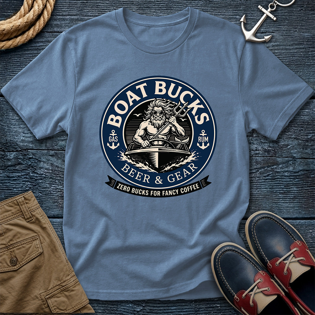 A blue crewneck t-shirt with a circular 'Boat Bucks Beer & Gear' graphic, styled in a flat lay on a dark wood background with a rope, anchor, shorts, and boat shoes.