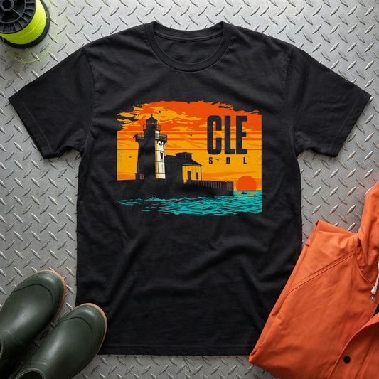 Black t-shirt with a lighthouse design and 'CLE SOL' text on a metal surface.