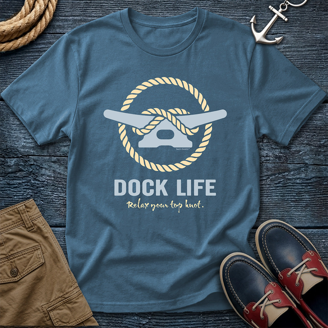 Blue t-shirt with 'Dock Life' graphic on a wooden surface with shorts and shoes.