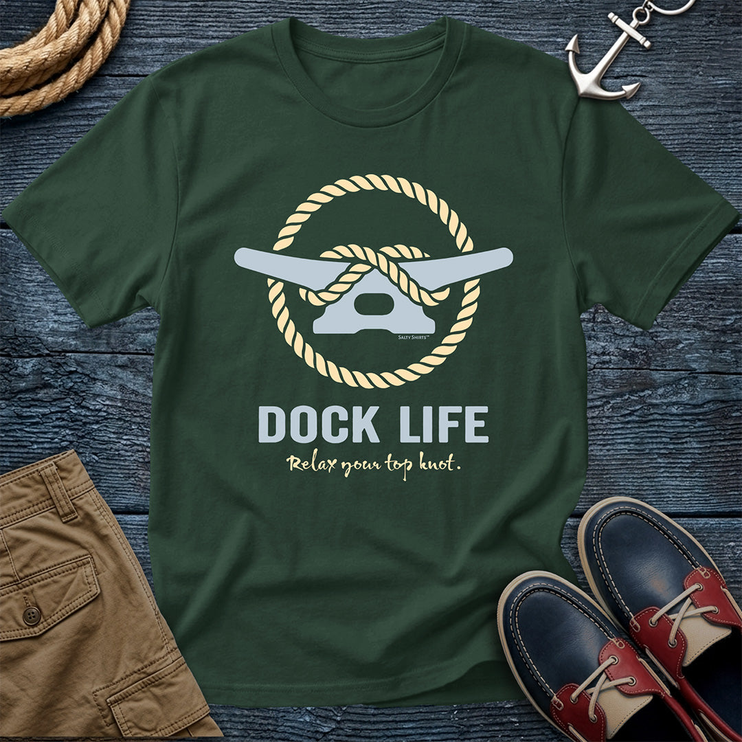 Green t-shirt with 'Dock Life' graphic on a wooden surface with shorts and shoes.