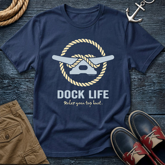 Navy blue t-shirt with 'Dock Life' graphic on a wooden surface with shorts and shoes.