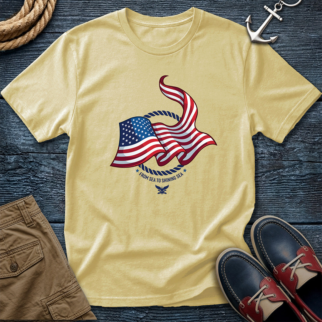 From Sea to Shining Sea American Flag Tee in Butter, Comfort Colors 1717 garment-dyed shirt with a waving American flag inside a rope ring, curved text, and eagle-and-anchors mark

