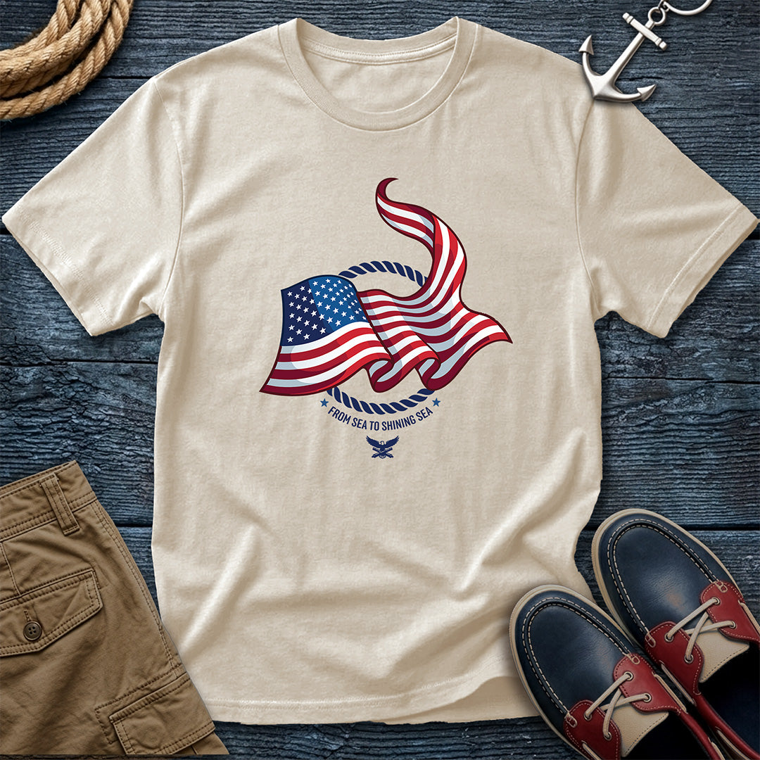 From Sea to Shining Sea American Flag Tee in Ivory, Comfort Colors 1717 garment-dyed shirt with a waving American flag inside a rope ring, curved text, and eagle-and-anchors mark