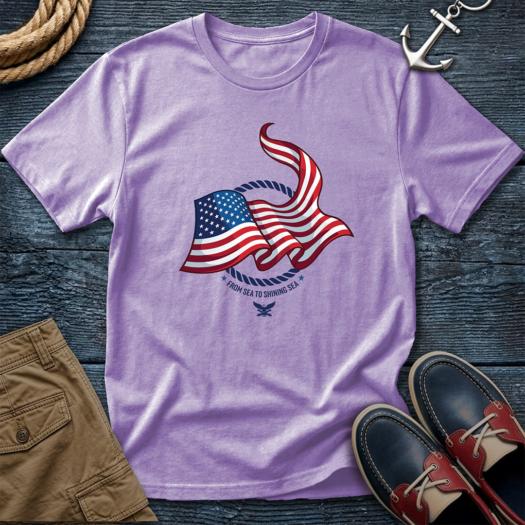 From Sea to Shining Sea American Flag Tee in Orchid, Comfort Colors 1717 garment-dyed shirt with a waving American flag inside a rope ring, curved text, and eagle-and-anchors mark
