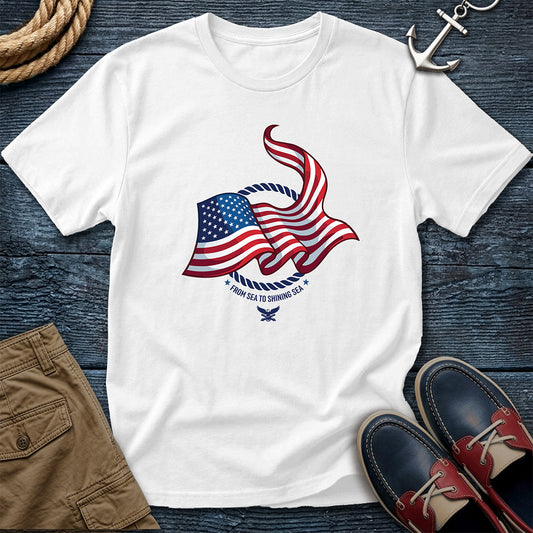 From Sea to Shining Sea American Flag Tee in White, Comfort Colors 1717 garment-dyed shirt with a waving American flag inside a rope ring, curved text, and eagle-and-anchors mark.
