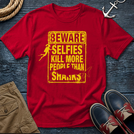 Red t-shirt with yellow text on a wooden surface with shoes and shorts.