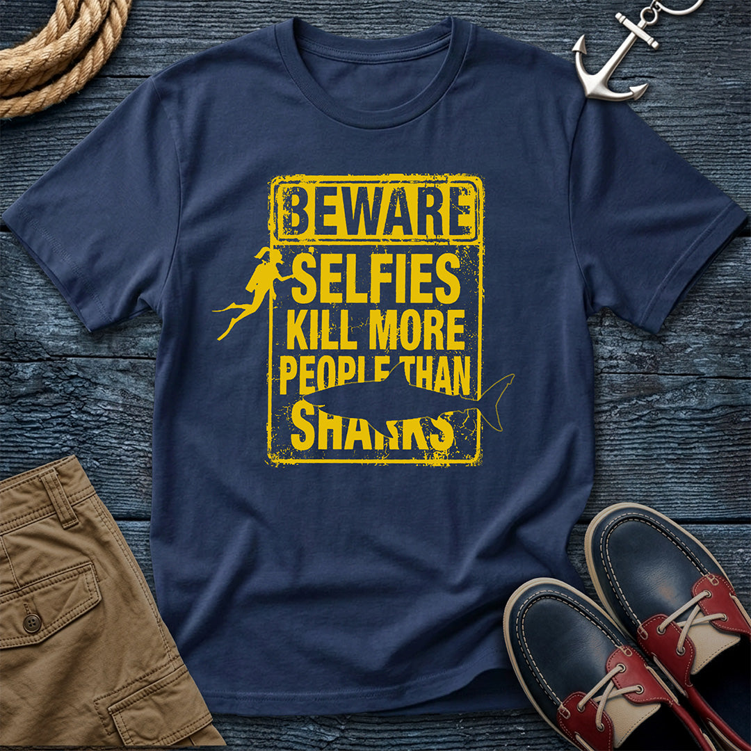 Navy blue t-shirt with yellow text on a wooden surface with shoes and shorts.