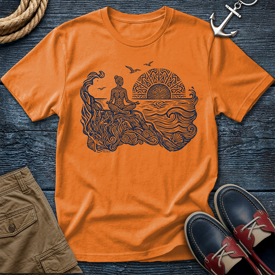Sunrise Shore Meditation Tee in Orange, Comfort Colors 1717 garment-dyed shirt with a seated shoreline figure, rising sun, geometric mandala, waves, shells, kelp, and circling gulls.