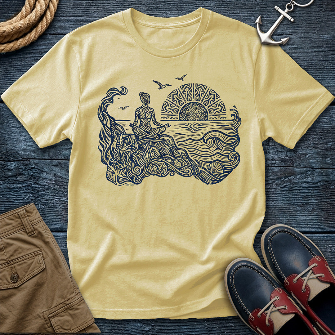 Sunrise Shore Meditation Tee in Butter, Comfort Colors 1717 garment-dyed shirt with a seated shoreline figure, rising sun, geometric mandala, waves, shells, kelp, and circling gulls.