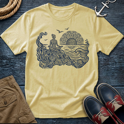 Sunrise Shore Meditation Tee in Butter, Comfort Colors 1717 garment-dyed shirt with a seated shoreline figure, rising sun, geometric mandala, waves, shells, kelp, and circling gulls.