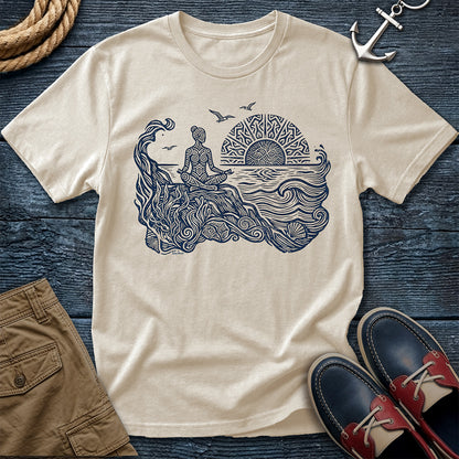 Sunrise Shore Meditation Tee in Ivory, Comfort Colors 1717 garment-dyed shirt with a seated shoreline figure, rising sun, geometric mandala, waves, shells, kelp, and circling gulls.