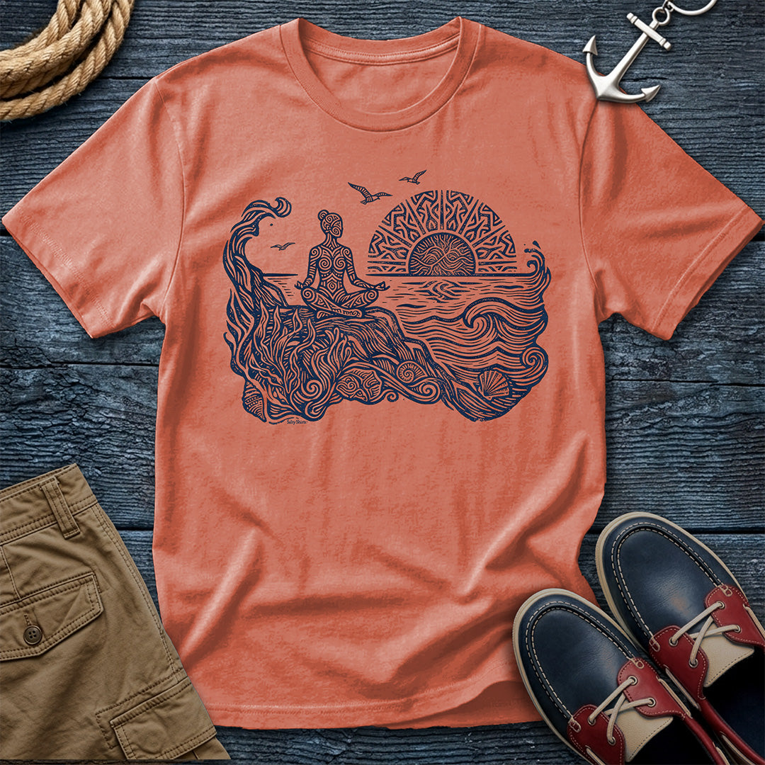 Sunrise Shore Meditation Tee in Terracotta, Comfort Colors 1717 garment-dyed shirt with a seated shoreline figure, rising sun, geometric mandala, waves, shells, kelp, and circling gulls.