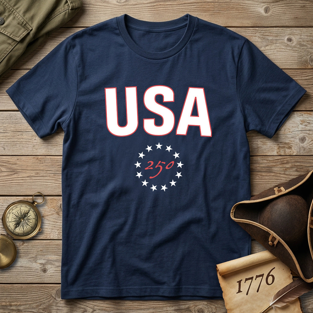 Navy blue t-shirt with 'USA 250' design on a wooden surface with vintage items.